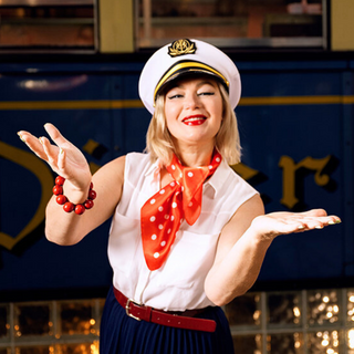 Woman in a vintage sailor costume with a train in the background
