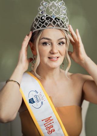 Woman wearing a tiara and Miss Ohio sash against a neutral background