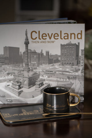 Book titled 'Cleveland Then and Now' with a mug and tray on a wooden surface